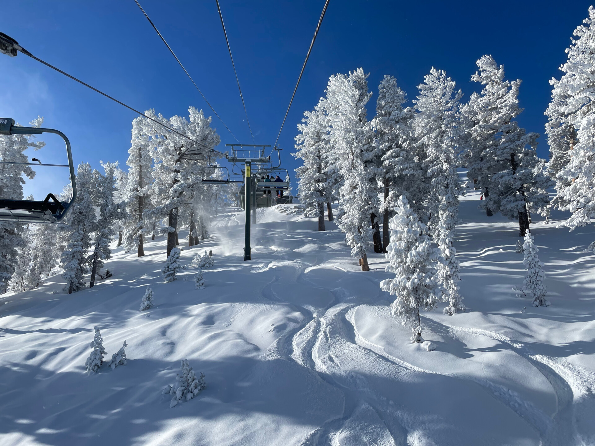 View of the chairlift, trees and slopes at a ski resort in Tahoe on a bluebird winter day